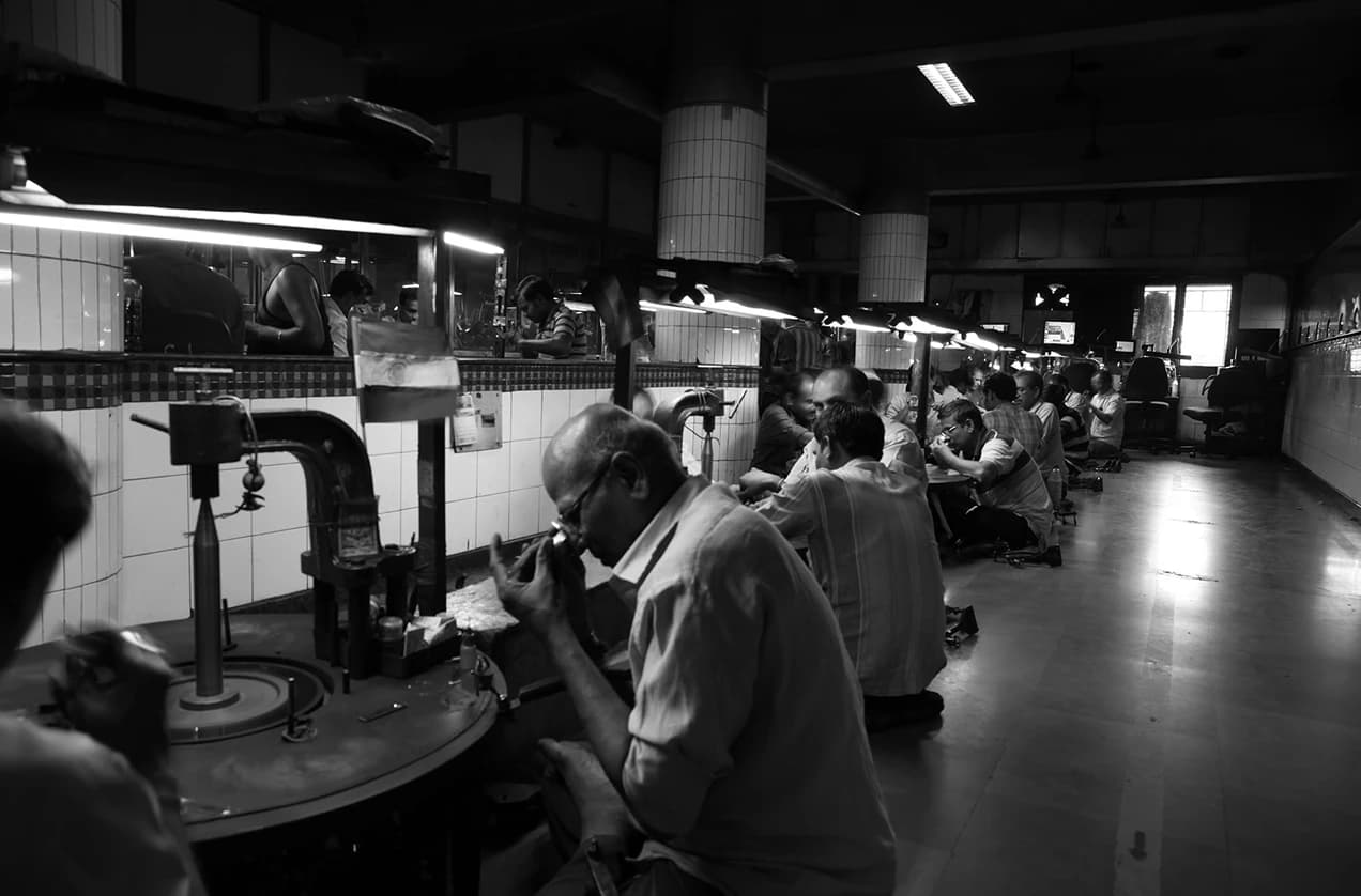 A craftsman inspecting a diamond at his workbench