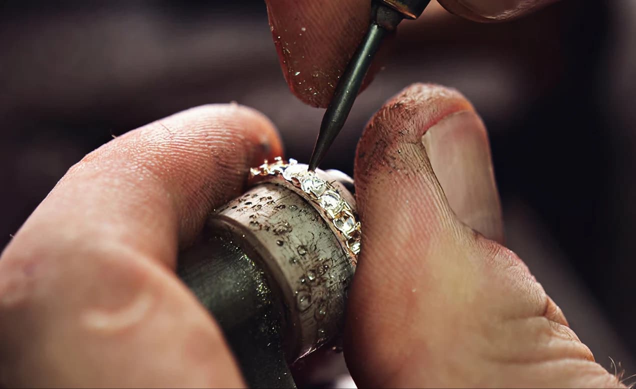A jeweller's hands setting a stone