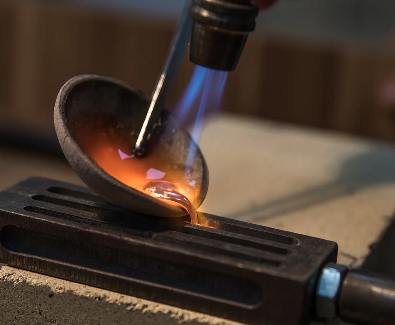 Goldsmith melting metal with a torch in the KGK workshop